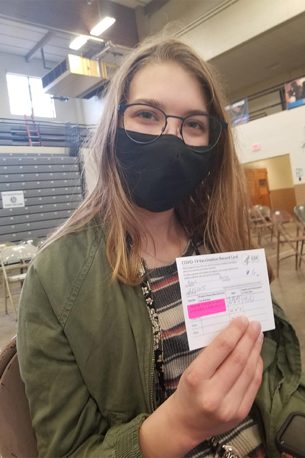 Sophomore+Anna+Earl+holds+up+the+certificate+that+proves+that+she+has+received+her+COVID-19+vaccine+after+receiving+her+first+shot+in+March.