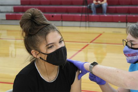 Senior Kenzie Pickens receives her first dose of the Pfizer COVID vaccine on April 9 in the Jack Stephens Gym.