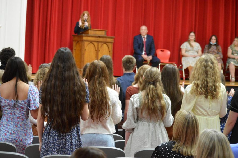 New+inductees+raise+their+right+hand+to+take+the+National+Honor+Society+oath+led+by+President+Emma+Fleming.