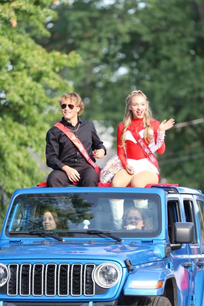 Homecoming king and queen Andrew Shafer and Kadie Anderson throw candy during the homecoming parade on Sept. 13.  