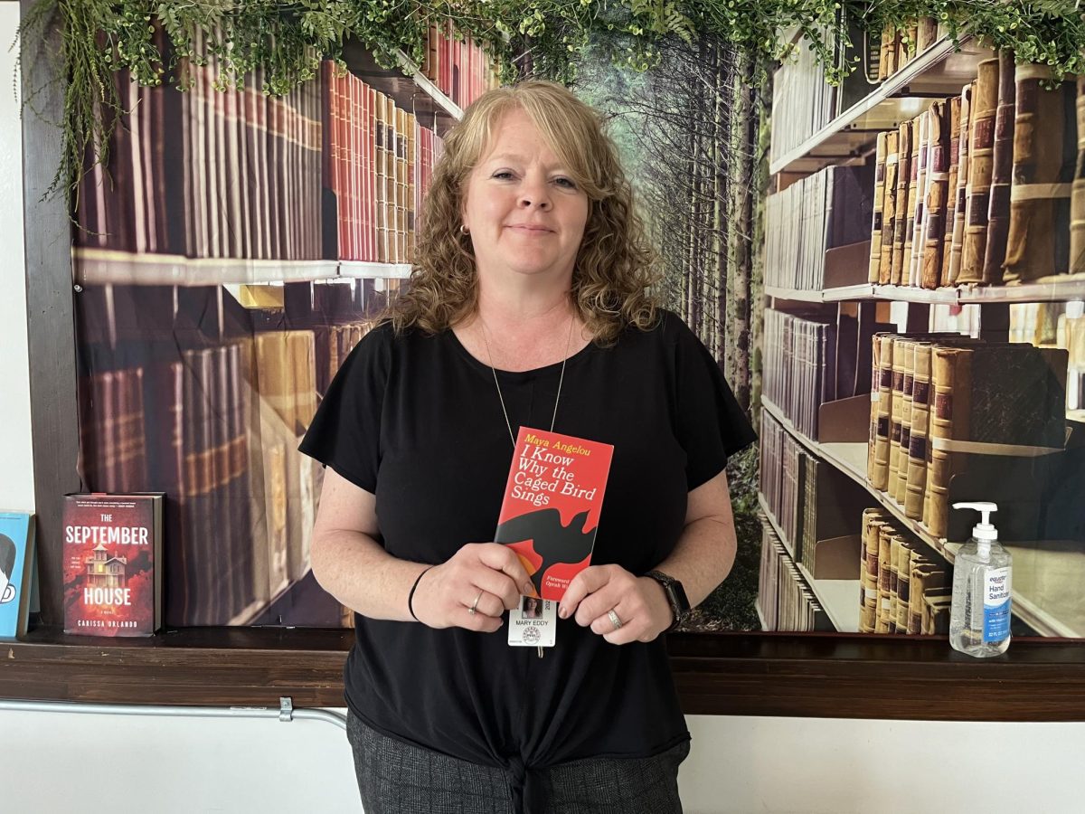 English teacher Mary Eddy with her favorite banned book, “I Know Why the Caged Bird Sings”.