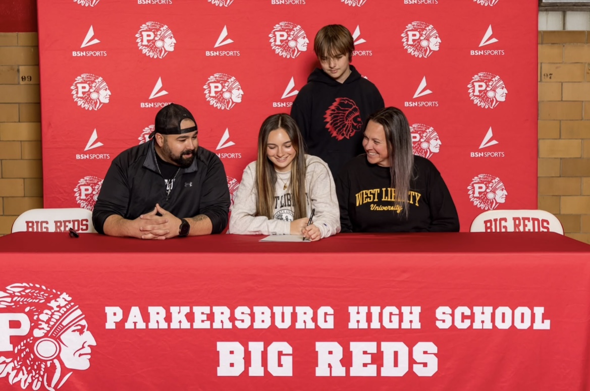 Senior Ellie Hines signs to West Liberty on Dec. 2 in the Fieldhouse mini gym while surrounded by her father, Caitlin Hines, her mother, Katie Hines, and her brother, Wade Hines.