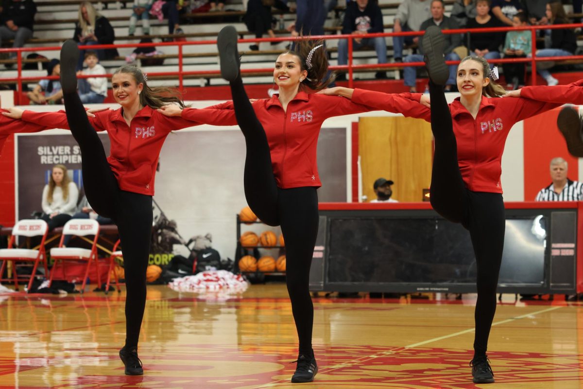 Junior Emma Stanley, senior Grace Smith and junior Emma Coleman perform "Speed Drive" for the girls basketball game against Parkersburg South Dec. 19.