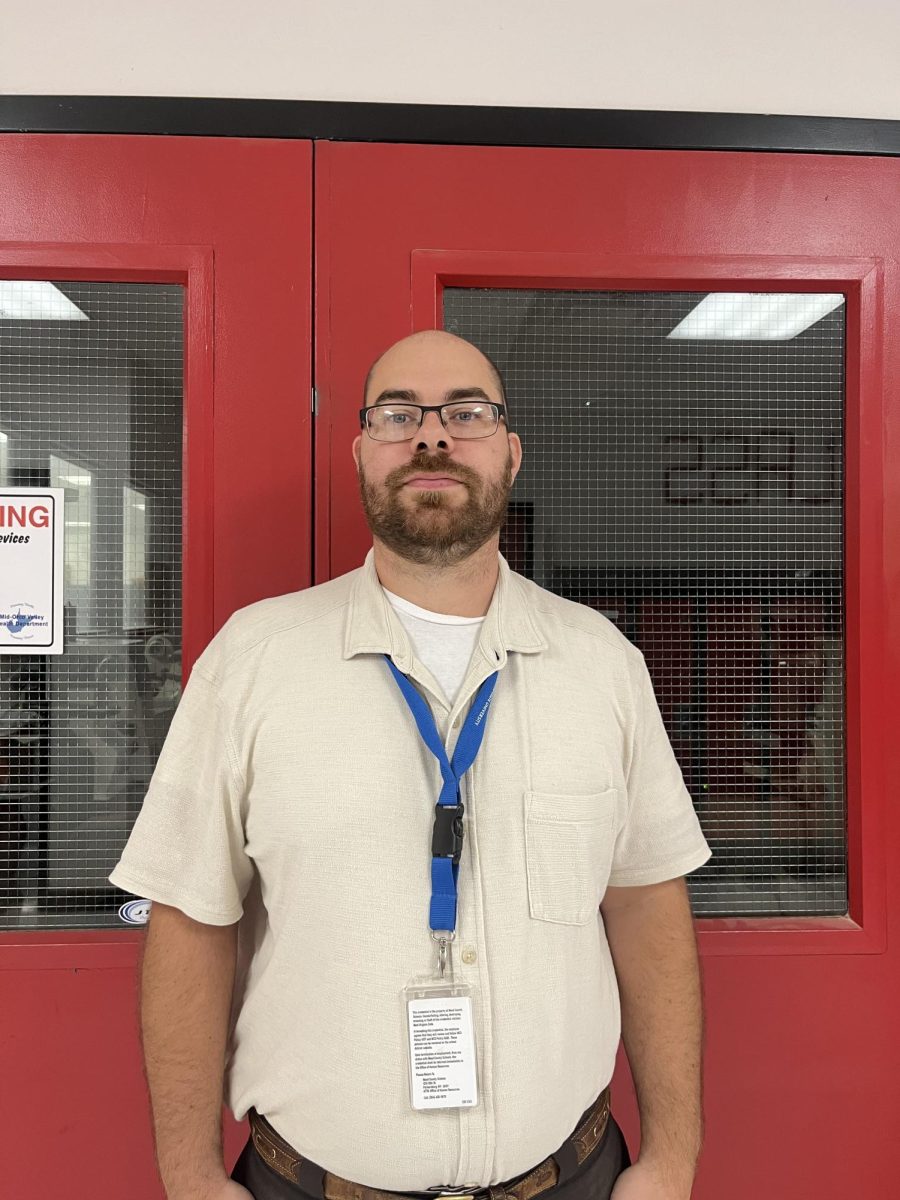 Shop teacher Andrew Anderson standing outside of his door. 