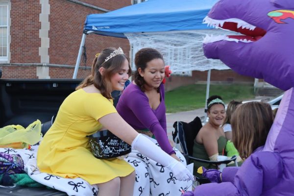 In the horseshoe Oct. 28, 2024, current seniors Aubrie Kendall and Mercedes Day hand out candy from the A Cappella Choir car during trunk or treat. Kendall and her group gave out at least eight bags of candy.