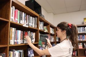 Librarian Sheena Dotson re-shelves a book in the library