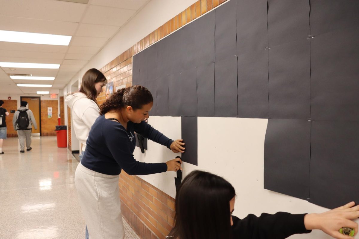 Senior member Amy Lantz, president Sadie Day and junior member Sheyla Almaguer decorating the DSU bulletin board on Sept. 10 for Hispanic Heritage Month. 