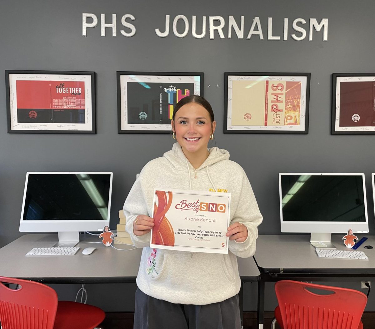Senior staff member Aubrie Kendall posing for a picture with her Best of SNO certificate.