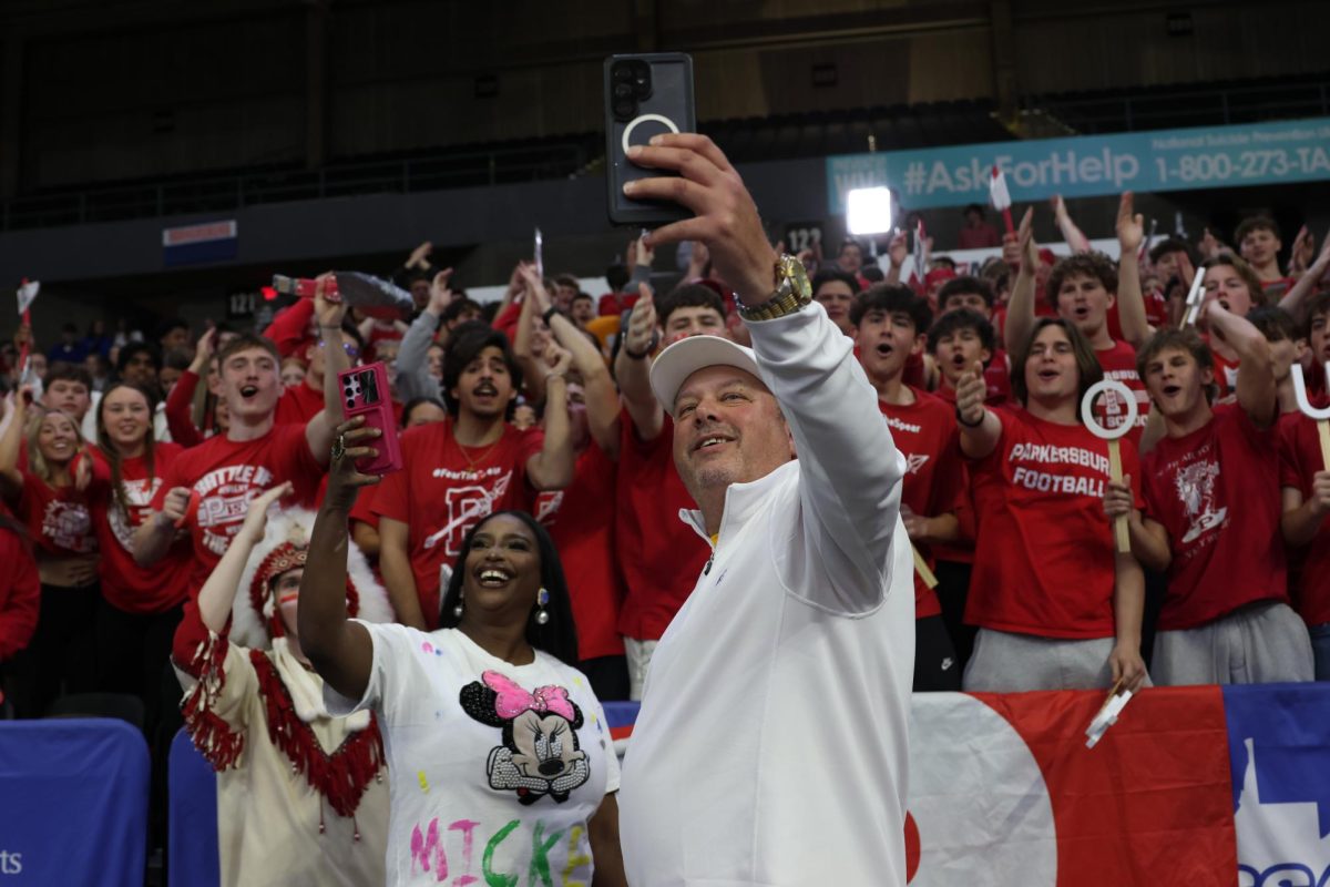 Referee Jason Wilkinson takes a video with the student section March 14.