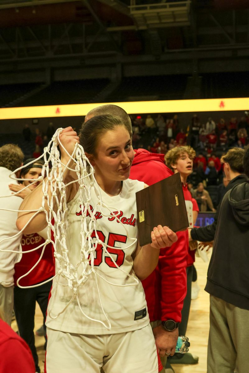 Senior Eden DeBord poses with a net and her championship plaque March 14.