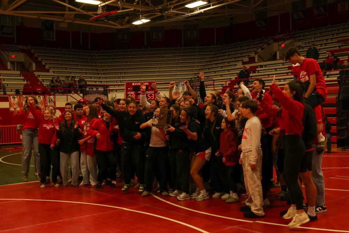 Students celebrate with the girls basketball team while making a TikTok in the Fieldhouse March 14.
