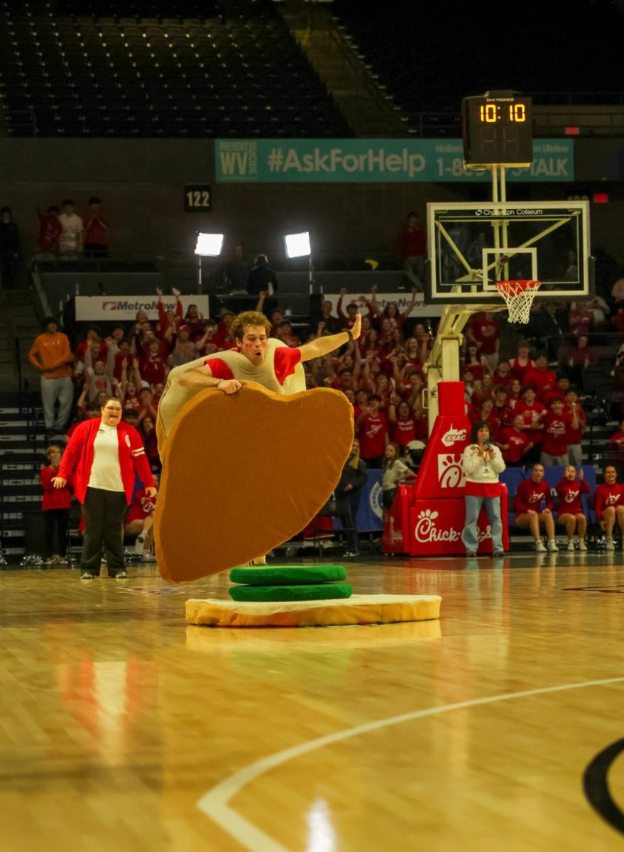 Senior Landen Deuley finishes building his chicken sandwich during the Chick-fil-A halftime games March 14. Deuley beat South's player and won a free tray of Chick-fil-A chicken nuggets.
