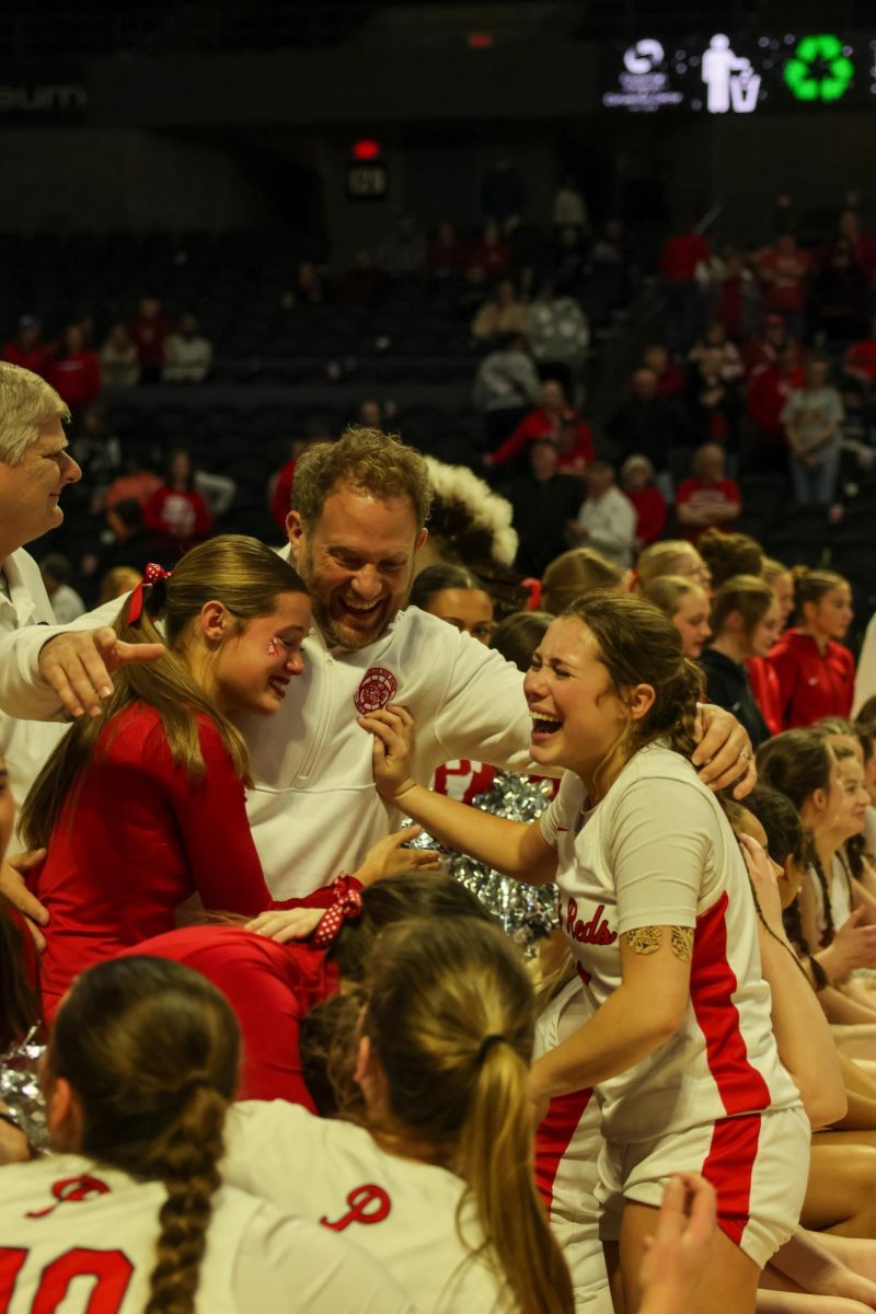 Freshman Anna Flanagan, Coach Rudy Flanagan and senior Lauren Flanagan celebrate after the girls basketball team won the state championship.